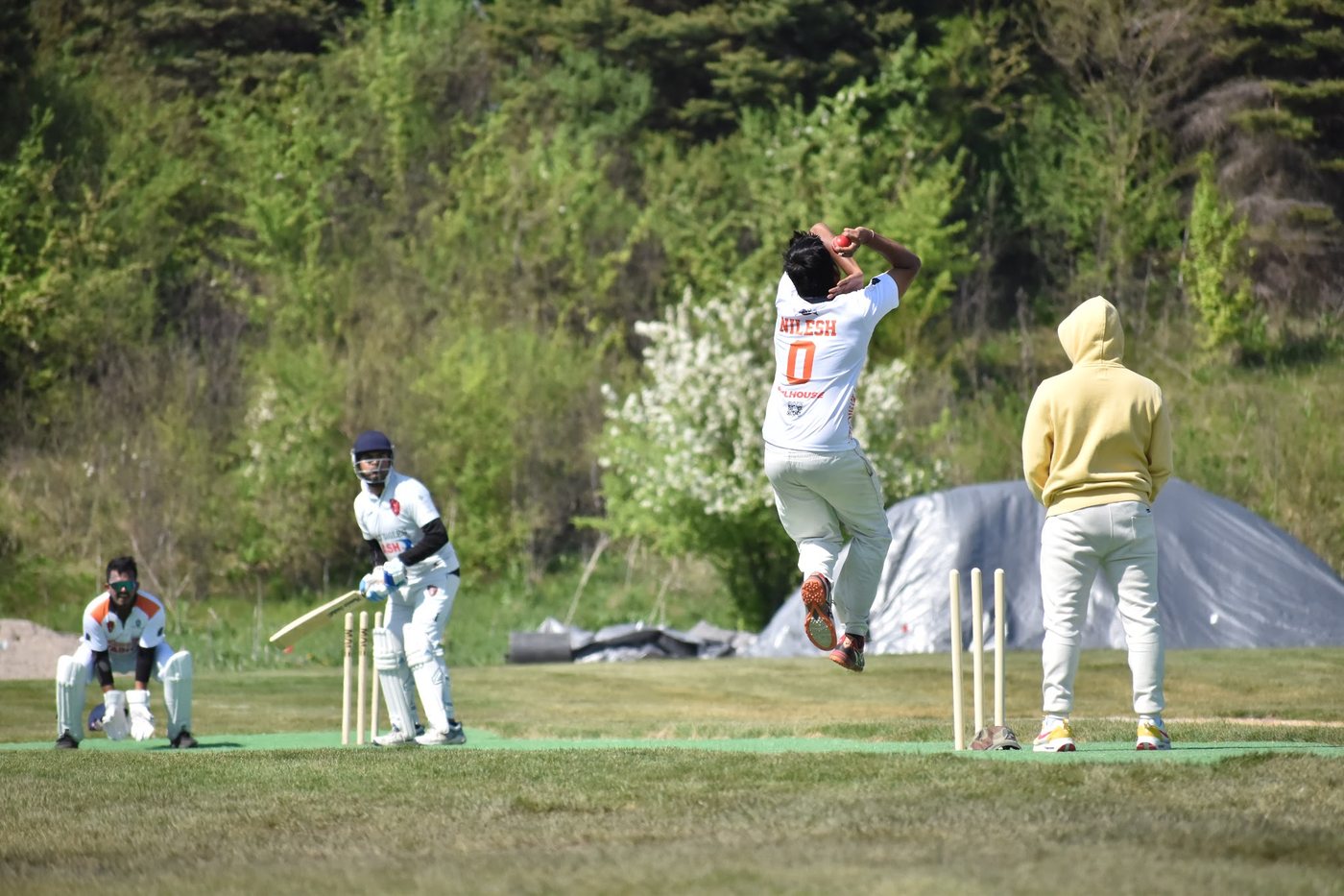 Nilesh fully airborne in his delivery leap