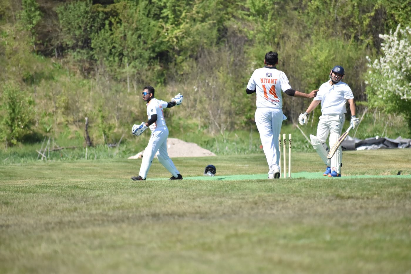 Wicket! Nitant strides through the celebration with the keeper's arms spread